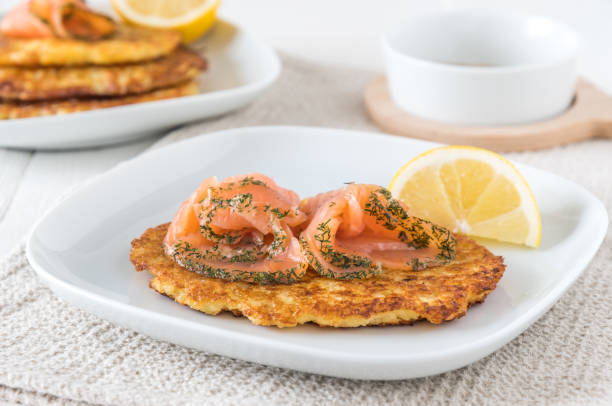 istock Potato pancake with salmon and lemon on white background 1319825003