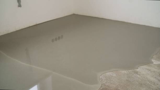 istock Workers level the floor with mortar. Self-priming liquid floor. Adjust the mixed cement in the mold. Floor repair. 1319826029