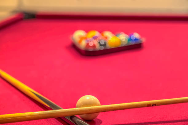 istock Red pool table with billiard balls and cue sticks 1319828161