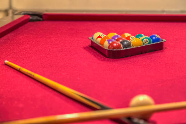 istock Pool table with sticks and cue balls 1319828271