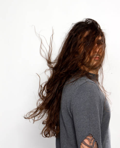 istock Attractive young guy with very long curly hair is posing in studio. 1319829020