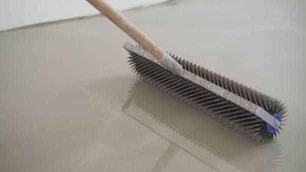 istock Leveling the floors with a cement mixture. Needle roller for self-leveling floor. Epoxy concept. concrete floor. on the horizon. 1319829767