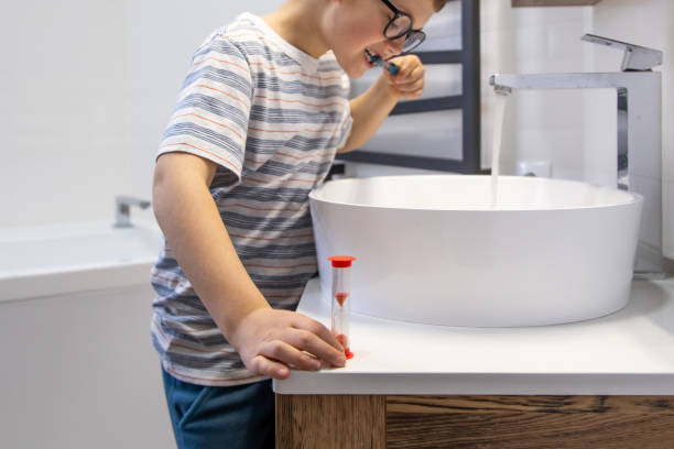 istock A little boy with glasses in the bathroom brushes his teeth. 1319830450