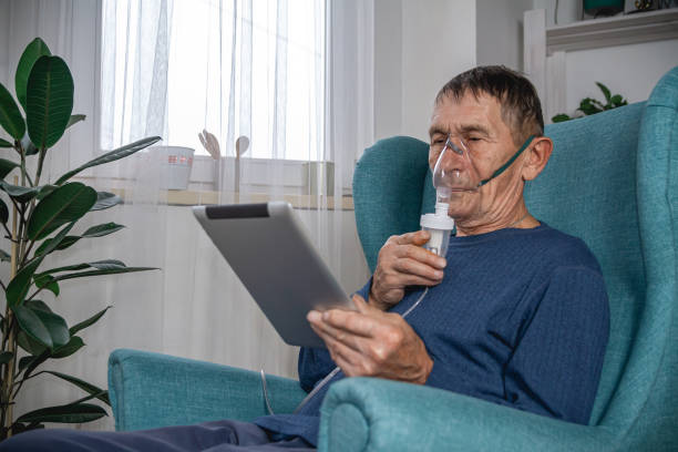 istock elderly senior sits in a armchair with an oxygen mask and tablet 1319830596