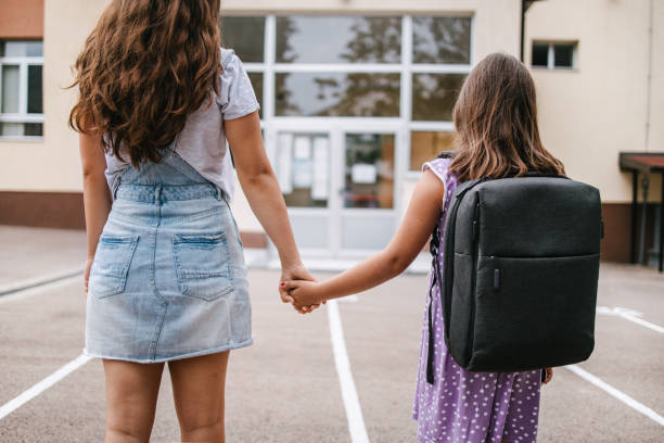 istock Big sister holding hands with her younger sister 1319831767