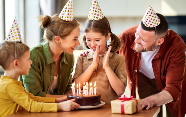 istock Excited little girl looking at cake and making wish while celebr 1319834027