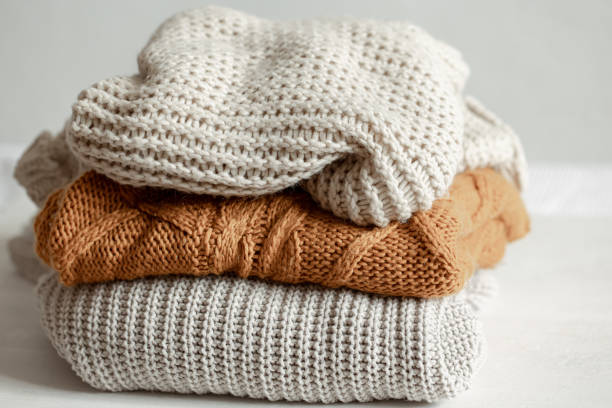 istock A stack of warm knitted sweathers on blurred background. 1319834067