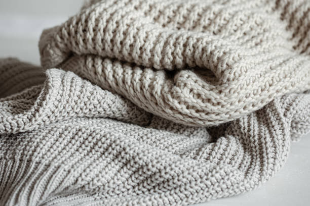 istock Cozy and warm knitted sweaters in pastel colors close-up. 1319834077