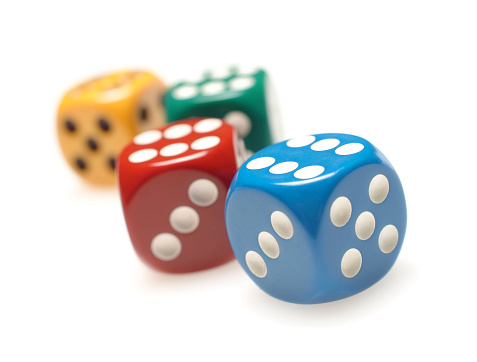 four colorful dice on white background with selective focus