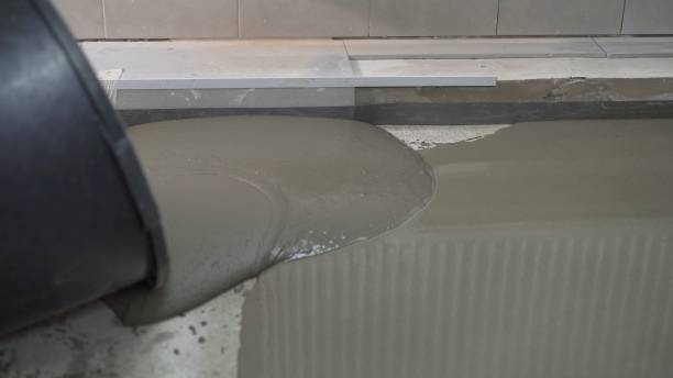 istock Leveled dry cement-sand mixture on the floor surface in a building under construction. Concrete work on filling floors with hand tools. The process of filling the floor with mortar. 1319836166