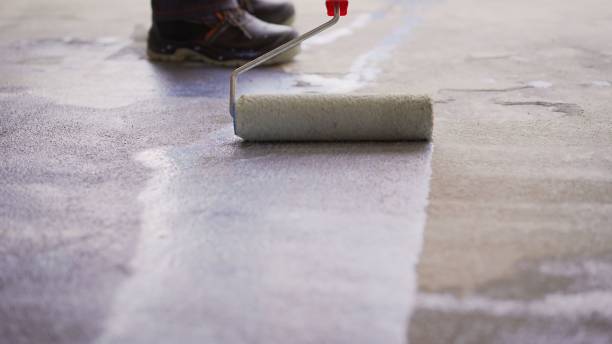 istock Priming Concrete floor before laying tiles on it, the final preparatory stage for strengthening the surface. Floor priming process. 1319836242