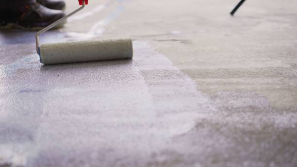 istock Priming the concrete floor with a roller. Professional floor primer. Leveling concrete floors. Floor repair using a primer. 1319836244