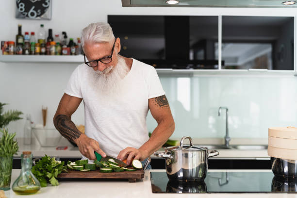 집에서 즐거운 요리를하는 행복한 노인 - 현대 주방에서 건강 점심을 준비하는 노인 - 은퇴 한 라이프 스타일 시간 및 음식 영양 개념 - chef cooking pasta professional occupation 뉴스 사진 이미지