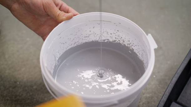 istock The white paint is mixed in a bucket with a drill. Drill paddle mixer on a bucket with white paint, DIY tools and accessory, banner 1319836729
