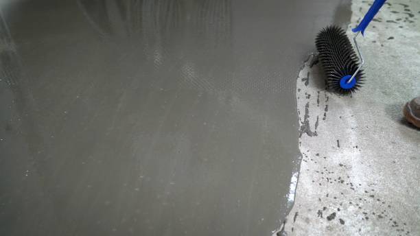 istock The needle roller is a tool for self-leveling floors. Self-leveling floor process. The worker levels the floor with a needle roller. 1319836742