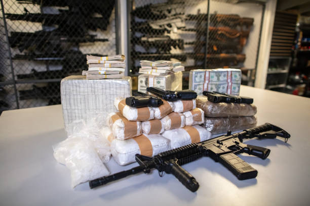 Money, Guns and Drugs in Police Armory A pile of money, drugs and guns in an armory or police evidence room. cocaine photos stock pictures, royalty-free photos & images