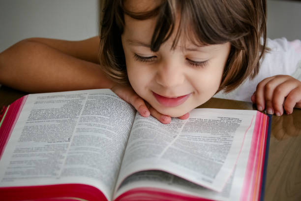 istock Child with reading bible holy book on the table. 1319839023