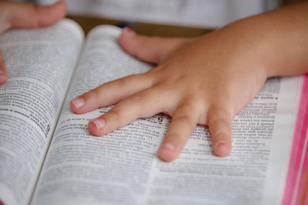 istock Child with reading bible holy book on the table. 1319839065