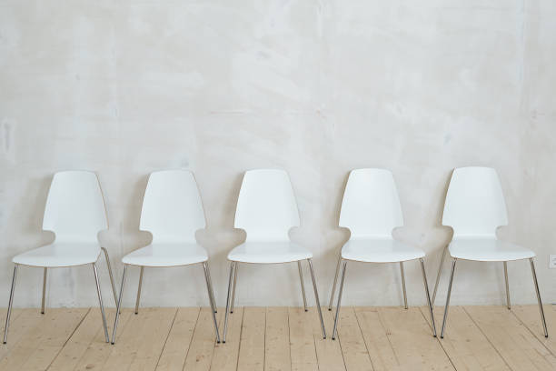 istock Row of white chairs near wall 1319840318