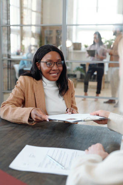 istock Smiling Afro-American woman giving her CV to HR manager 1319840407