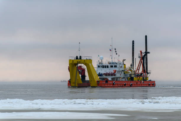 istock Vessel engaged in dredging at sunset time. Hopper dredger working at sea. Ship excavating material from a water environment. 1319842734