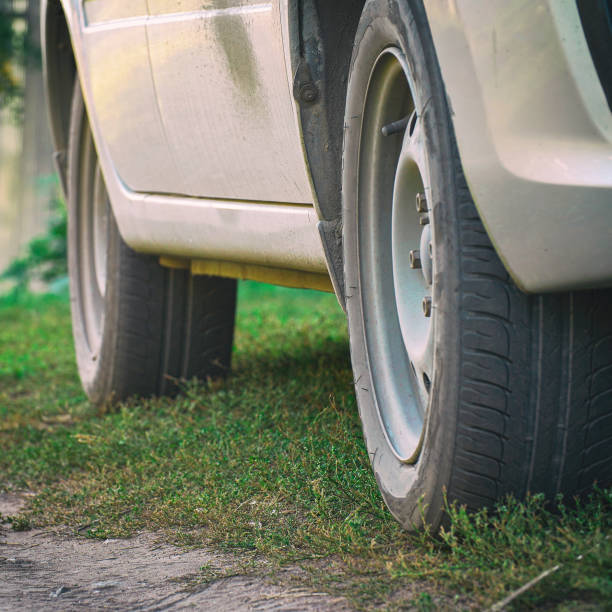 istock Wheels of a car standing on dirt road 1319842866