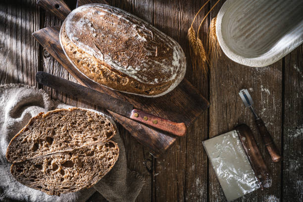 istock Sourdough bread loaf and Banneton basket in bakery on wooden rustic table 1319843132