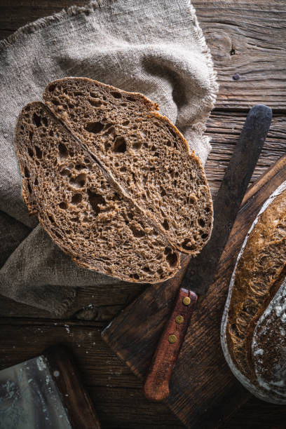istock Sourdough bread loaf and Banneton basket in bakery on wooden rustic table 1319843149