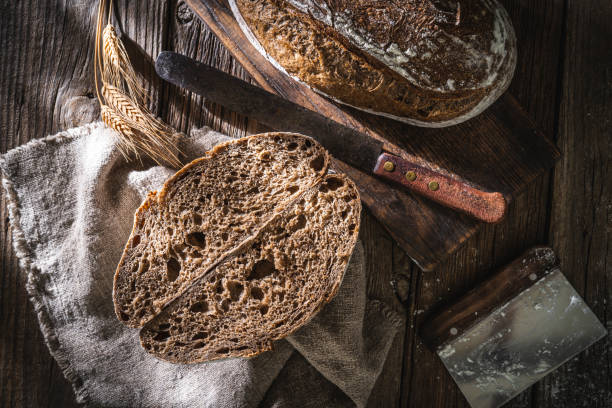 istock Sourdough bread loaf and Banneton basket in bakery on wooden rustic table 1319843165