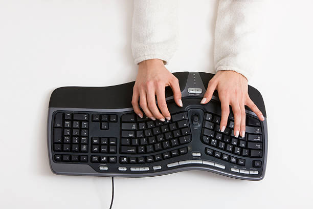 Typing Woman typing  on computer keyboard, canon 1Ds mark III              ergonomic keyboard photos stock pictures, royalty-free photos & images
