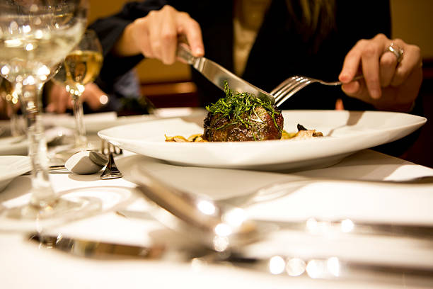 Woman eating tarragon crusted beef tenderloin, gnocchi, mushrooms and artichokes, canon 1Ds mark III