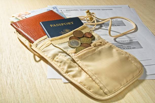 istock Security pouch with travel itinerary, foreign currency, coins, passport and billfold on table 1319844571