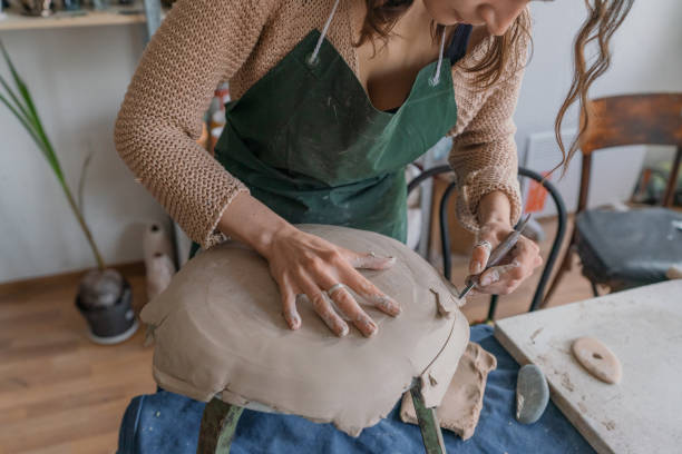istock Female ceramist working in her studio, making plate 1319845719