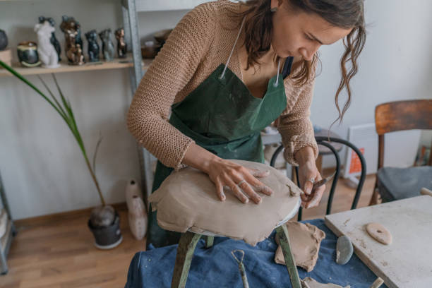 istock Female ceramist working in her studio, making plate 1319845741