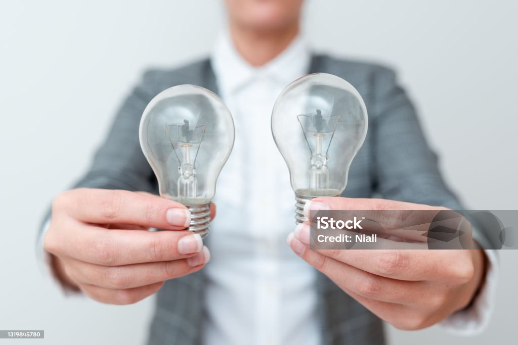 Lady Carrying Two Lightbulbs In Hands With Formal Outfit Presenting Another Ideas For Project, Business Woman Holding 2 Lamps Showing Late Technologies, Lighbulb Exhibiting Fresh Openion Lady Carrying Two Lightbulbs In Hands With Formal Outfit Presenting Another Ideas For Project, Business Woman Holding 2 Lamps Showing Late Technologies, Lighbulb Exhibiting Fresh Openion. 35-39 Years Stock Photo
