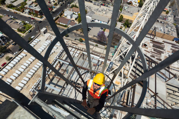 istock Construction Worker Climbing A Ladder at the Top of A Crane 1319845861
