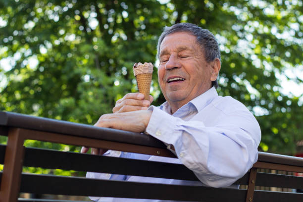 istock Happy senior Man eating ice cream 1319847766