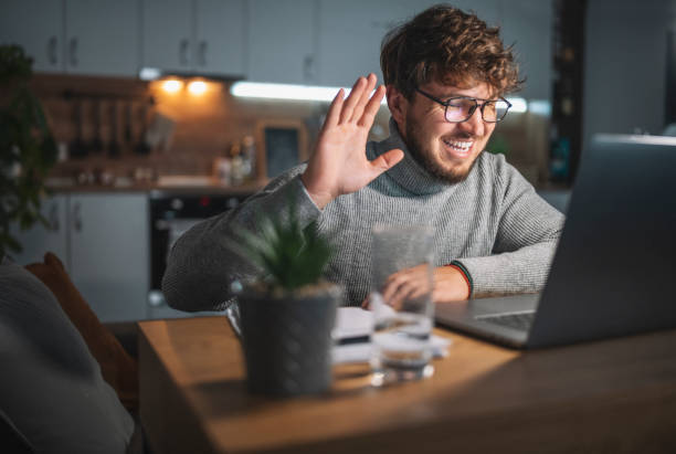 istock Handsome man in video call at home at evening. 1319848565