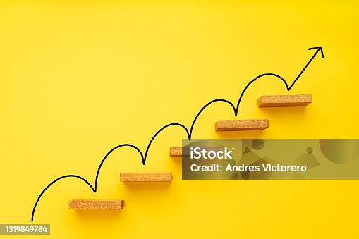 istock Rising arrow on staircase on yellow background 1319849784