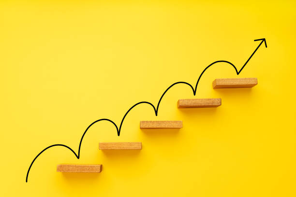 Rising arrow on staircase on yellow background Rising arrow on staircase on yellow background. Growth, increasing business, success process concept. Copy space development stock pictures, royalty-free photos & images