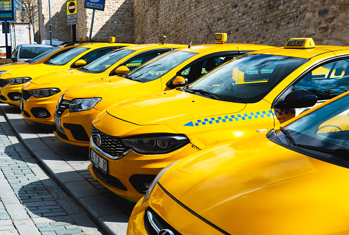 April 10, 2021, Istanbul, Turkey: Yellow city taxi cars stand in a row in the parking lot