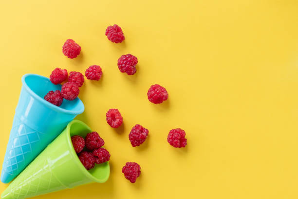istock colorful Waffle cone with fresh organic raspberries on bright background. Summer berries,Pop art design, creative concept.greeting card,space for text. social media blogs 1319850349