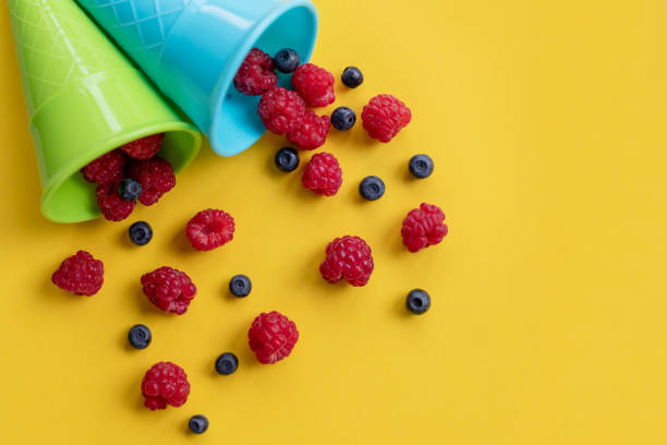 Fresh blueberries, raspberries and blackberries in cartons shot from above.