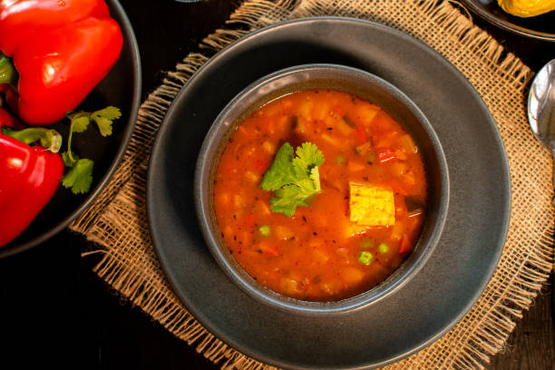 istock Mexican tomato, bean, bell pepper soup and corn in the dark bowl. 1319851084