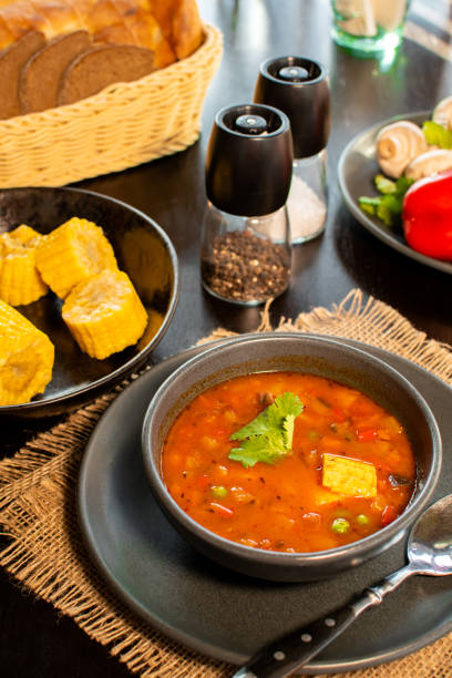 istock Mexican tomato, bean, bell pepper soup and corn in the dark bowl. 1319851088