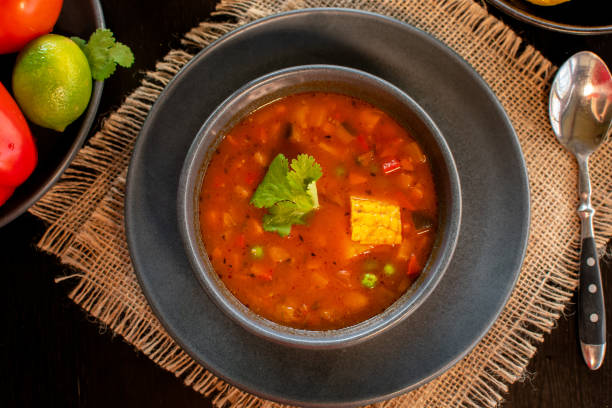 istock Mexican tomato, bean, bell pepper soup and corn in the dark bowl. 1319851090