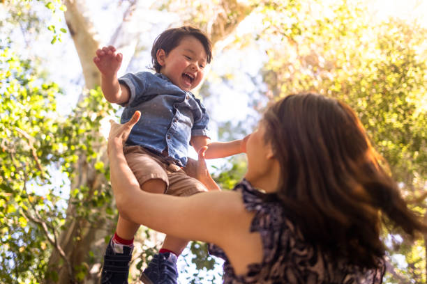 мама подъем ее сын в воздухе - baby child parent toddler стоковые фото и изображения