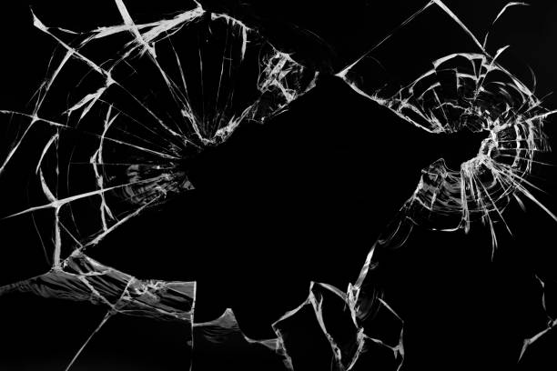 istock Cracks in the glass, with holes from bullets on a black background. 1319852436