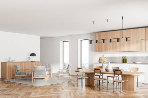 istock Stylish interior of bright and white modern kitchen room with dining table and chairs. Armchairs livingroom zone open space. 1319852936