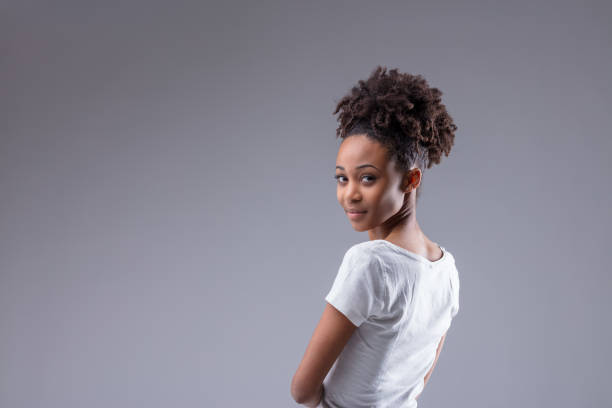 Young Black woman looking back at camera over her shoulder